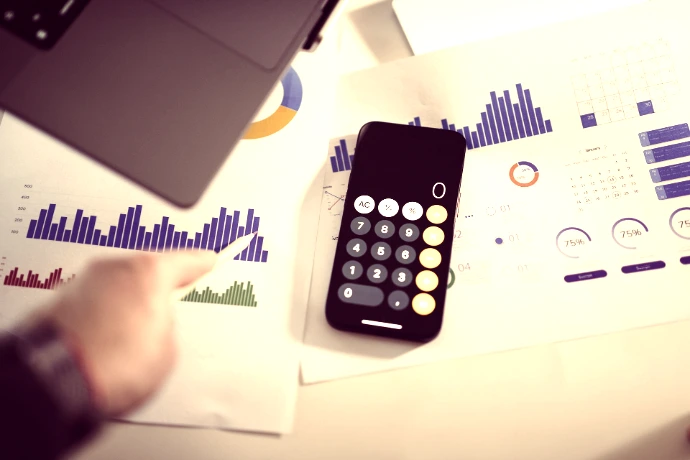 a calculator sitting on top of a table next to a laptop